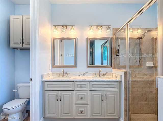 bathroom with toilet, vanity, and a shower with door