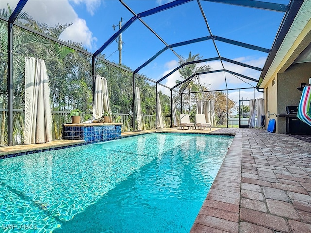 view of swimming pool featuring a patio and a lanai