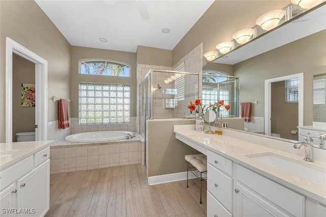 full bathroom featuring vanity, separate shower and tub, toilet, and wood-type flooring