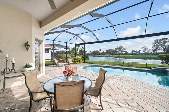 view of pool featuring a lanai, a patio area, and a water view