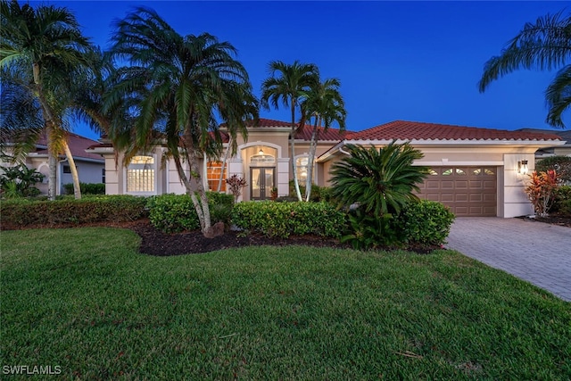 mediterranean / spanish-style home with a front lawn and a garage