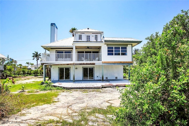 rear view of house featuring ceiling fan and a patio area