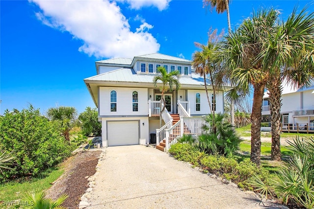 coastal home with a porch and a garage