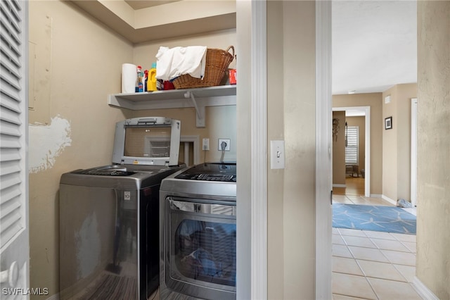 laundry area featuring light tile patterned flooring and washing machine and clothes dryer