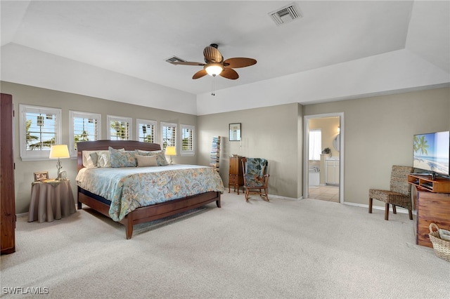 carpeted bedroom with a tray ceiling, ceiling fan, and ensuite bathroom