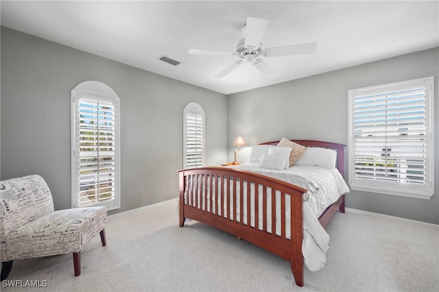 bedroom with multiple windows, light carpet, and ceiling fan