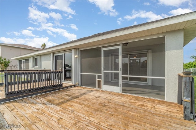 wooden deck with a sunroom