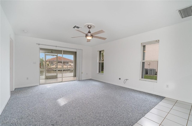 empty room with ceiling fan and light tile patterned floors