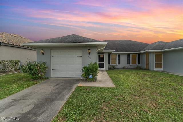 single story home featuring a lawn and a garage