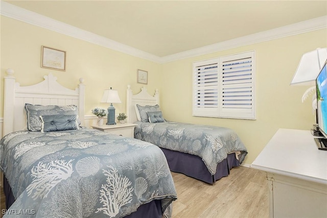 bedroom featuring ornamental molding and light hardwood / wood-style flooring