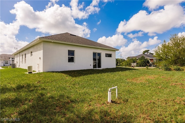 back of house featuring central AC and a lawn