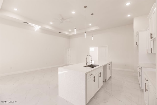 kitchen featuring white cabinets, hanging light fixtures, an island with sink, dishwasher, and sink