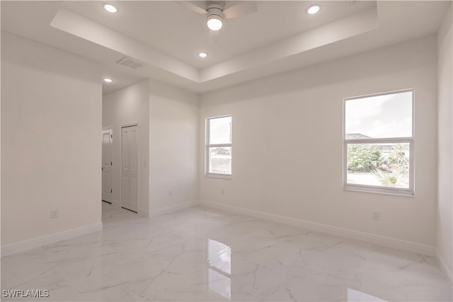 unfurnished room featuring a tray ceiling and ceiling fan