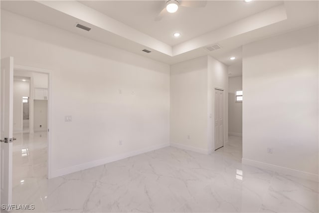 empty room with a tray ceiling and ceiling fan