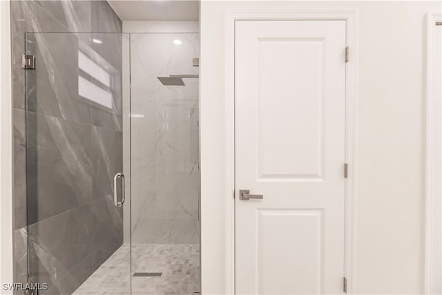 bathroom featuring a shower with door