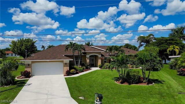 mediterranean / spanish home featuring a garage, a front yard, concrete driveway, and stucco siding