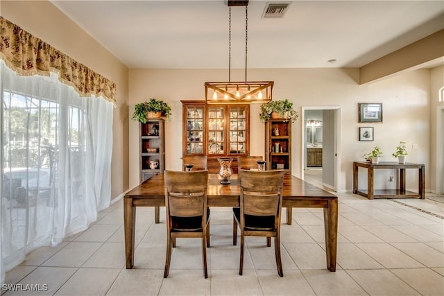 dining space with light tile patterned floors, baseboards, and visible vents