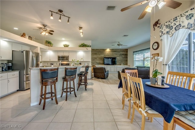 kitchen featuring light tile patterned floors, stainless steel appliances, visible vents, open floor plan, and white cabinetry