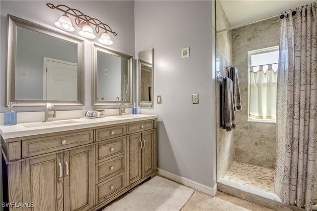 full bathroom featuring double vanity, tiled shower, a sink, and tile patterned floors