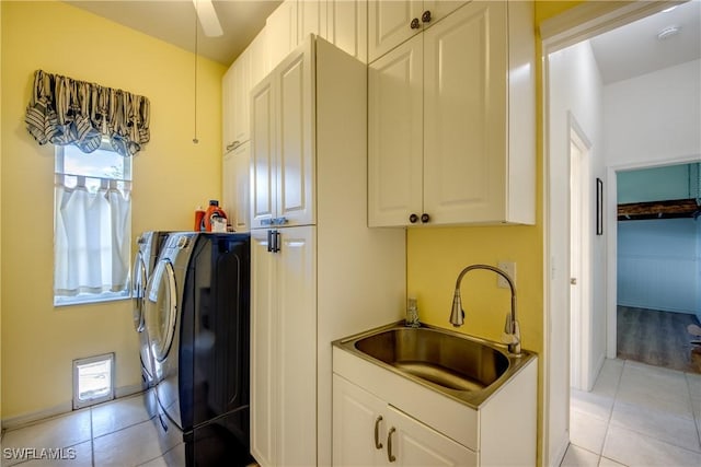 laundry room with a sink, light tile patterned floors, washing machine and clothes dryer, and cabinet space