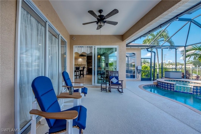 exterior space featuring a lanai, a pool with connected hot tub, ceiling fan, and a patio area