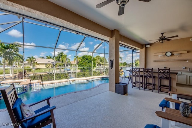 view of swimming pool with a pool with connected hot tub, glass enclosure, a patio, and outdoor dry bar