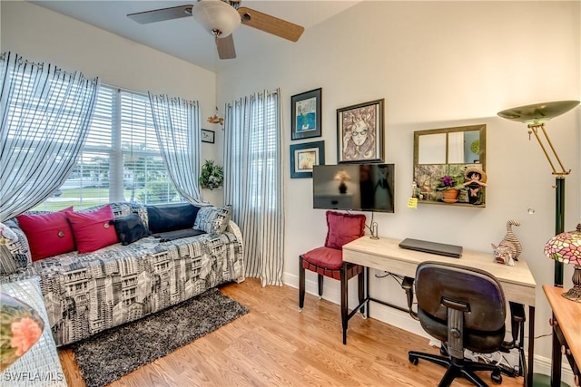 office area with baseboards, a ceiling fan, and wood finished floors