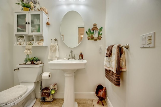 bathroom with tile patterned flooring, toilet, and baseboards