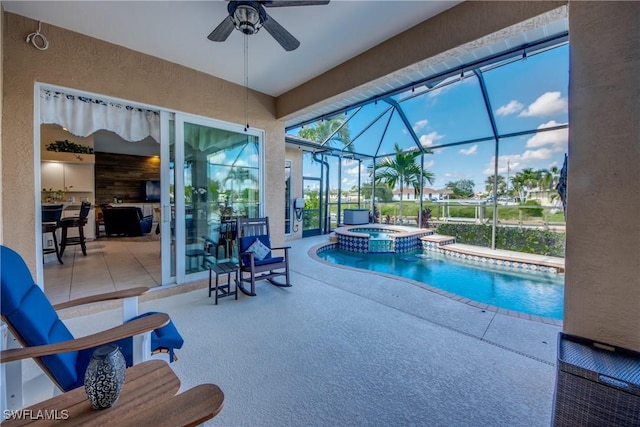 view of swimming pool featuring a lanai, a patio area, a pool with connected hot tub, and a ceiling fan