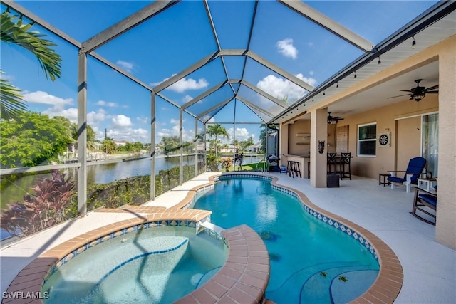 view of pool featuring glass enclosure, a water view, a pool with connected hot tub, outdoor dry bar, and a patio area