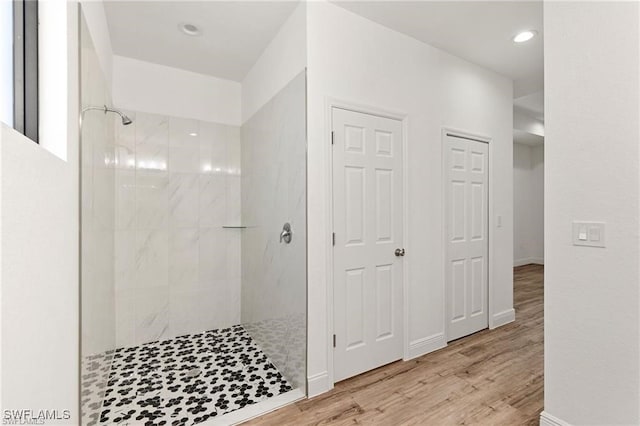 bathroom featuring hardwood / wood-style floors and tiled shower