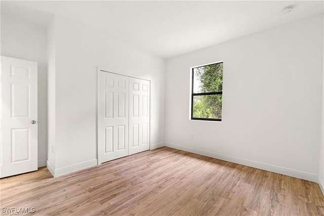 unfurnished bedroom with a closet and light hardwood / wood-style flooring