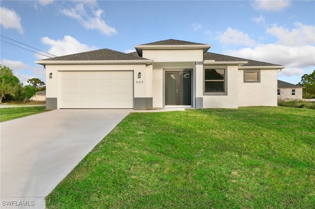 prairie-style home with a garage and a front lawn