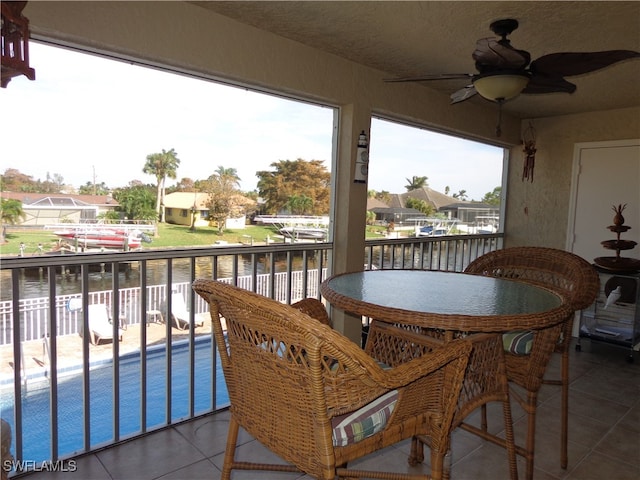 balcony with a water view and ceiling fan