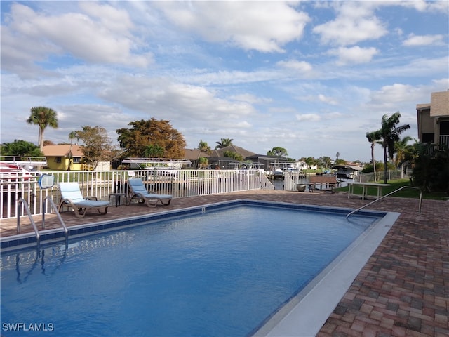 view of pool with a water view and a patio area