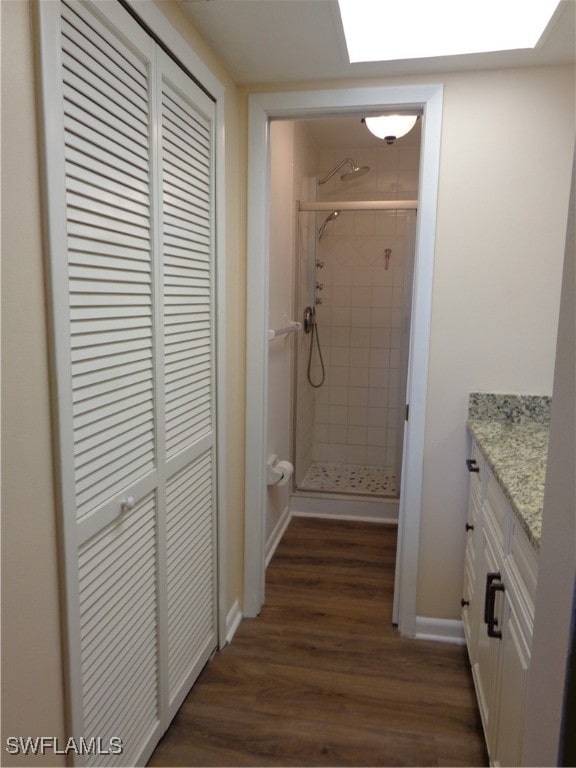 bathroom with vanity, hardwood / wood-style floors, and a tile shower