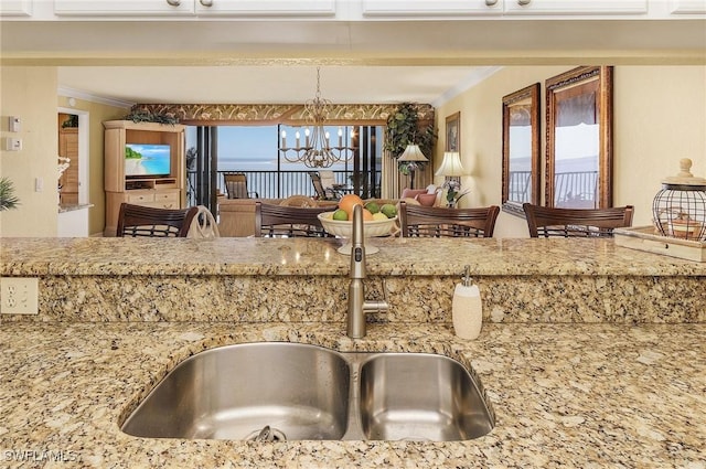 kitchen featuring an inviting chandelier, a wealth of natural light, pendant lighting, and sink