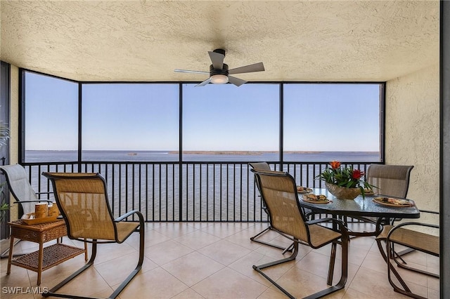 sunroom with a water view, ceiling fan, and plenty of natural light