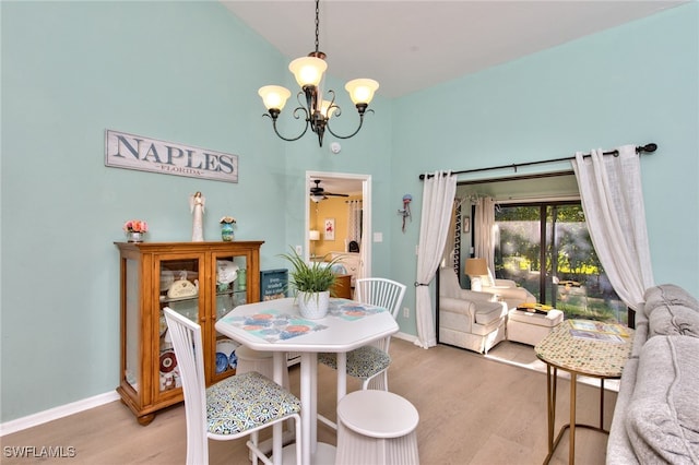 dining area with light wood-style floors, baseboards, vaulted ceiling, and ceiling fan with notable chandelier