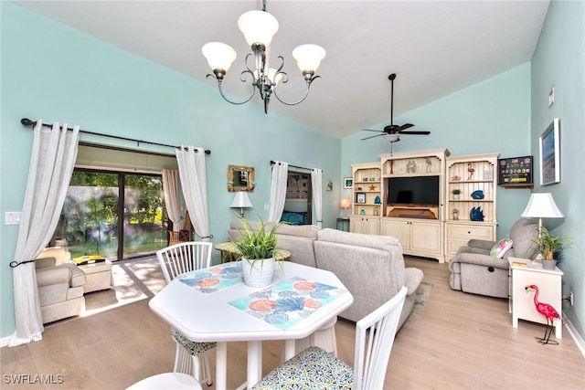 dining room featuring light wood-style floors, lofted ceiling, and ceiling fan with notable chandelier