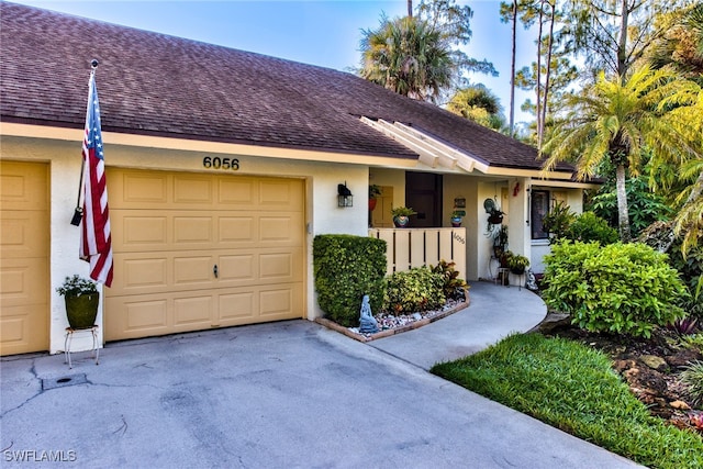 ranch-style home featuring a garage, roof with shingles, and stucco siding