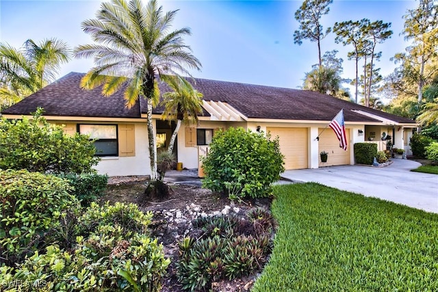 ranch-style house with roof with shingles, stucco siding, concrete driveway, an attached garage, and a front lawn