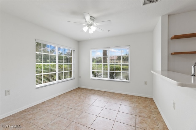 tiled empty room featuring ceiling fan