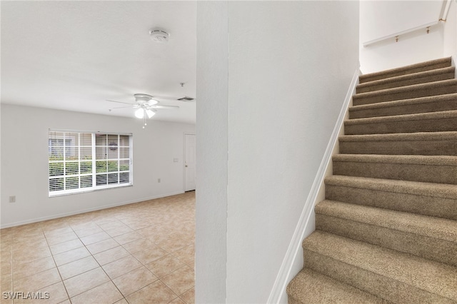 staircase featuring tile patterned floors and ceiling fan