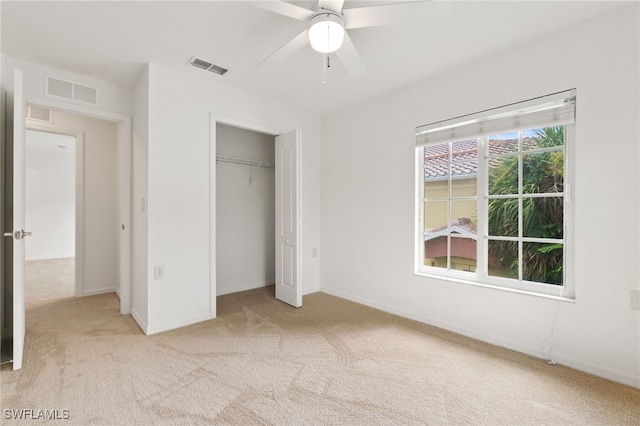 unfurnished bedroom featuring a closet, ceiling fan, and light carpet