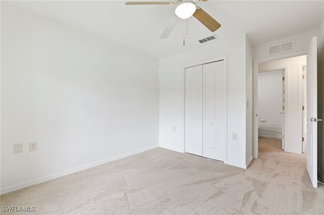 unfurnished bedroom featuring a closet, light colored carpet, and ceiling fan