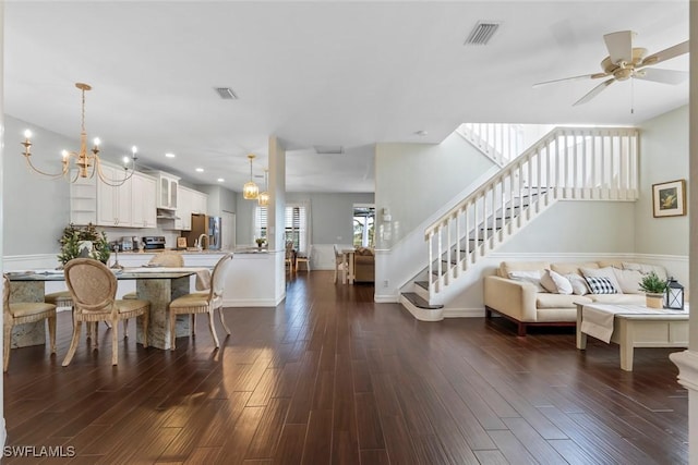 interior space with dark hardwood / wood-style floors and ceiling fan with notable chandelier