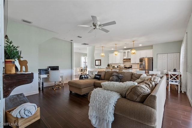 living room featuring ceiling fan and dark wood-type flooring