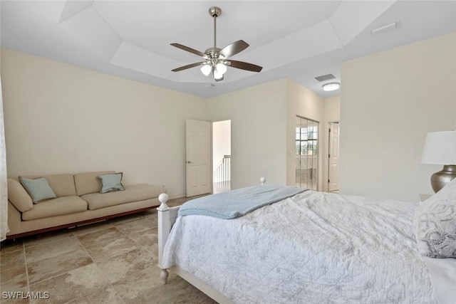 bedroom with a raised ceiling and ceiling fan