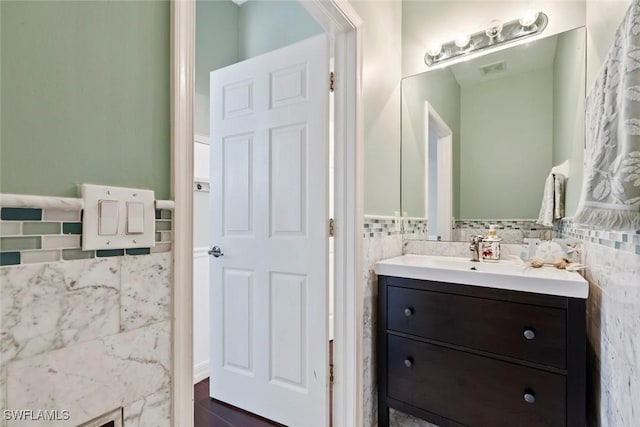 bathroom featuring vanity and tile walls